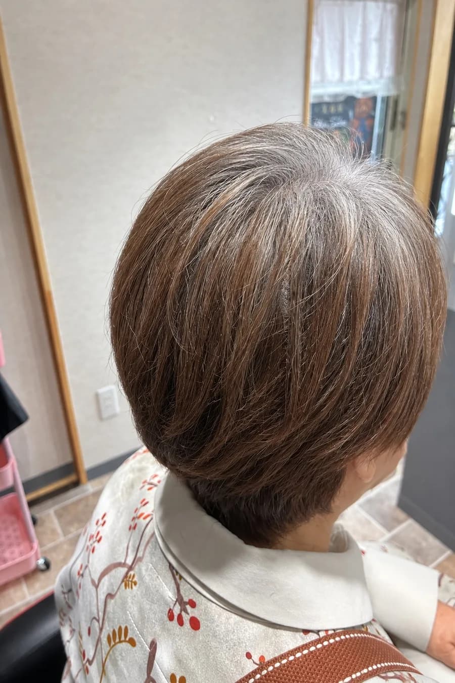 カラー前の、頭頂部や分け目に白髪が見えるショートヘアの横姿